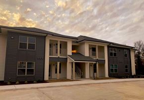 Bangs apartment for rent - an apartment building with a parking lot and a cloudy sky