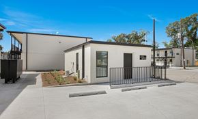 Houma townhouse for rent - A modern building with a black fence in front.