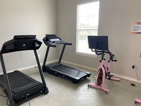 Bastrop apartment for rent - two exercise machines and a bike in a room with a window
