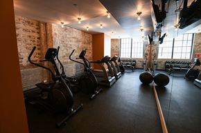 New Orleans apartment for rent - A gym with a row of stationary bikes and a row of treadmills.