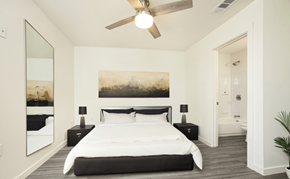 Houma townhouse for rent - A bedroom with a large bed and a painting on the wall.