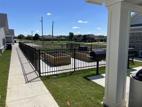 Sterlington apartment for rent - A black fence surrounds a grassy area with a white pillar on the right.