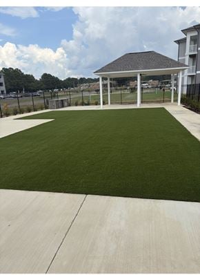 Shreveport apartment for rent - A gazebo is surrounded by a fence and a green lawn.