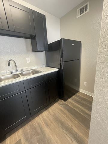 New Orleans apartment for rent - A black refrigerator in a kitchen with a white sink.