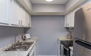 New Orleans apartment for rent - A kitchen with a black stove top oven and white cabinets.