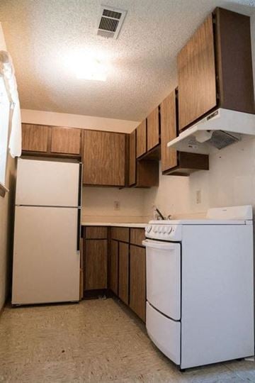 Monroe apartment for rent - a kitchen with white appliances and wooden cabinets