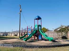 Monroe apartment for rent - a playground with three slides on a dirt field