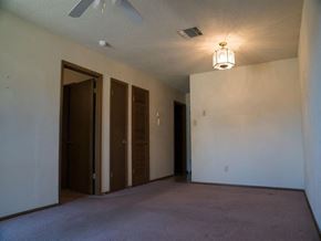 Monroe apartment for rent - an empty living room with a ceiling fan and two doors