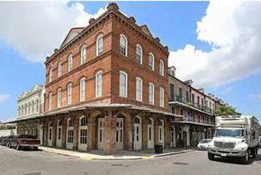 New Orleans apartment for rent - A red brick building with white trim and a truck parked in front.