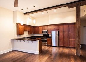 New Orleans apartment for rent - A kitchen with wooden cabinets and a white island.