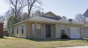 Scotlandville apartment for rent - a small tan brick house with a garage