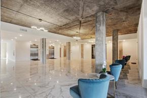 New Orleans apartment for rent - A large room with marble floors and a row of blue chairs.