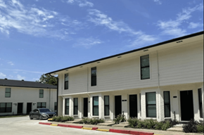 Gonzales apartment for rent - A white building with a black car parked in front.