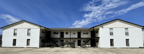 Baton Rouge apartment for rent - A white two-story building with a flat roof and a balcony on the second floor.