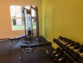 Natchitoches apartment for rent - A gym with a row of dumbbells and a bench.