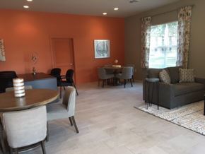 Natchitoches apartment for rent - A living room with a grey couch, a wooden table, and a window with curtains.