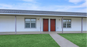 Shreveport apartment for rent - A white building with a red door and windows.