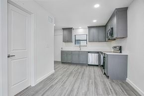 Gonzales apartment for rent - A kitchen with grey cabinets and a white door.