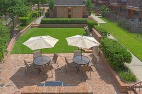 Harahan apartment for rent - A patio with a table and chairs and umbrellas.