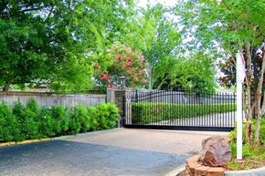 Harahan apartment for rent - A black gate with a metal fence and a stone pillar in front of it.