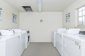 Shreveport apartment for rent - A row of white front load washing machines in a laundromat.