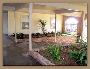 Slidell apartment for rent - A patio with a brick wall and plants.