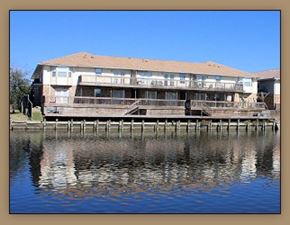 Slidell apartment for rent - A building is situated on a dock over water.