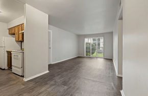 Shreveport apartment for rent - A spacious empty room with wooden flooring and white walls.