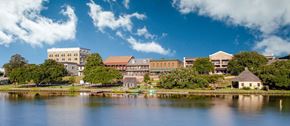 Natchitoches apartment for rent - A large building sits on the shore of a lake.
