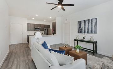 Baton Rouge apartment for rent - A living room with a white couch and a ceiling fan.