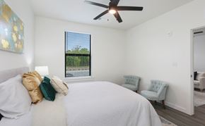 Baton Rouge apartment for rent - A bedroom with a large bed and a ceiling fan.