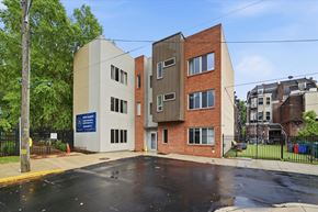 Philadelphia apartment for rent - A modern building with a blue sign in front of it.
