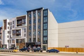 Philadelphia apartment for rent - A modern multi-story building with cars parked in front.