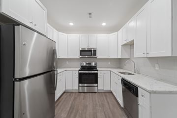 Philadelphia apartment for rent - A modern kitchen with white cabinets and stainless steel appliances.