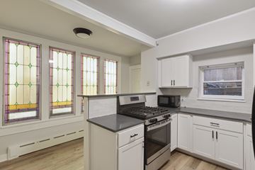 Philadelphia apartment for rent - a kitchen with white cabinets and a stove and a window