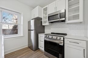 Philadelphia apartment for rent - A kitchen with white cabinets and a black stove top oven.