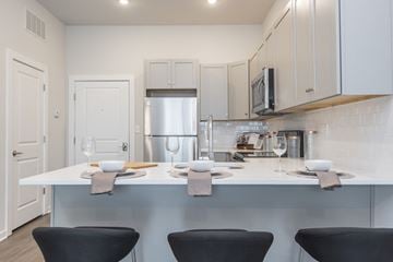 Philadelphia apartment for rent - a kitchen with a white counter top and black chairs