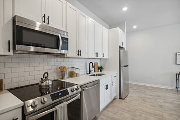Philadelphia apartment for rent - A modern kitchen with white cabinets and stainless steel appliances.