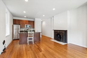Philadelphia apartment for rent - a living room with a fireplace and a kitchen with wooden floors
