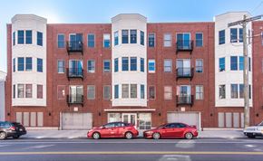 Philadelphia apartment for rent - a red brick apartment building with two red cars parked in front