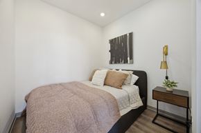 Philadelphia apartment for rent - a bedroom with white walls and a bed with a blanket and pillows at The Commons On Ludlow Apartments, Philadelphia, Pennsylvania