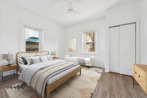 Philadelphia apartment for rent - A bedroom with a large bed and a window with a view of the roof of a building.