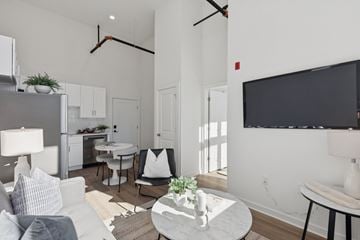 Philadelphia apartment for rent - A modern living room with a grey sofa, a white coffee table, and a black television mounted on the wall.