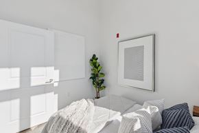 Philadelphia apartment for rent - A bedroom with a bed covered in a white blanket and a framed picture on the wall.