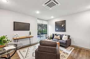 Philadelphia apartment for rent - A living room with a brown couch, a glass table, and a rug.