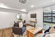 Philadelphia apartment for rent - A living room with a grey couch, a wooden coffee table, and a round mirror on the wall.