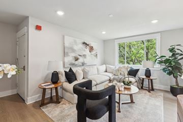 Philadelphia apartment for rent - A living room with a white couch, a black chair, and a large painting on the wall.