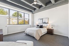 Philadelphia apartment for rent - A bedroom with a large bed and a window overlooking trees.