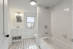 Philadelphia apartment for rent - a bathroom with white tiles and a white bathtub