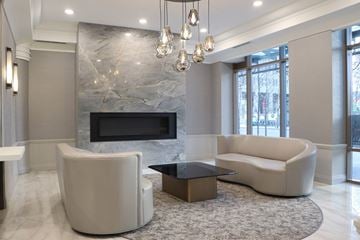 Toronto apartment for rent - a living room with two white chairs and a television